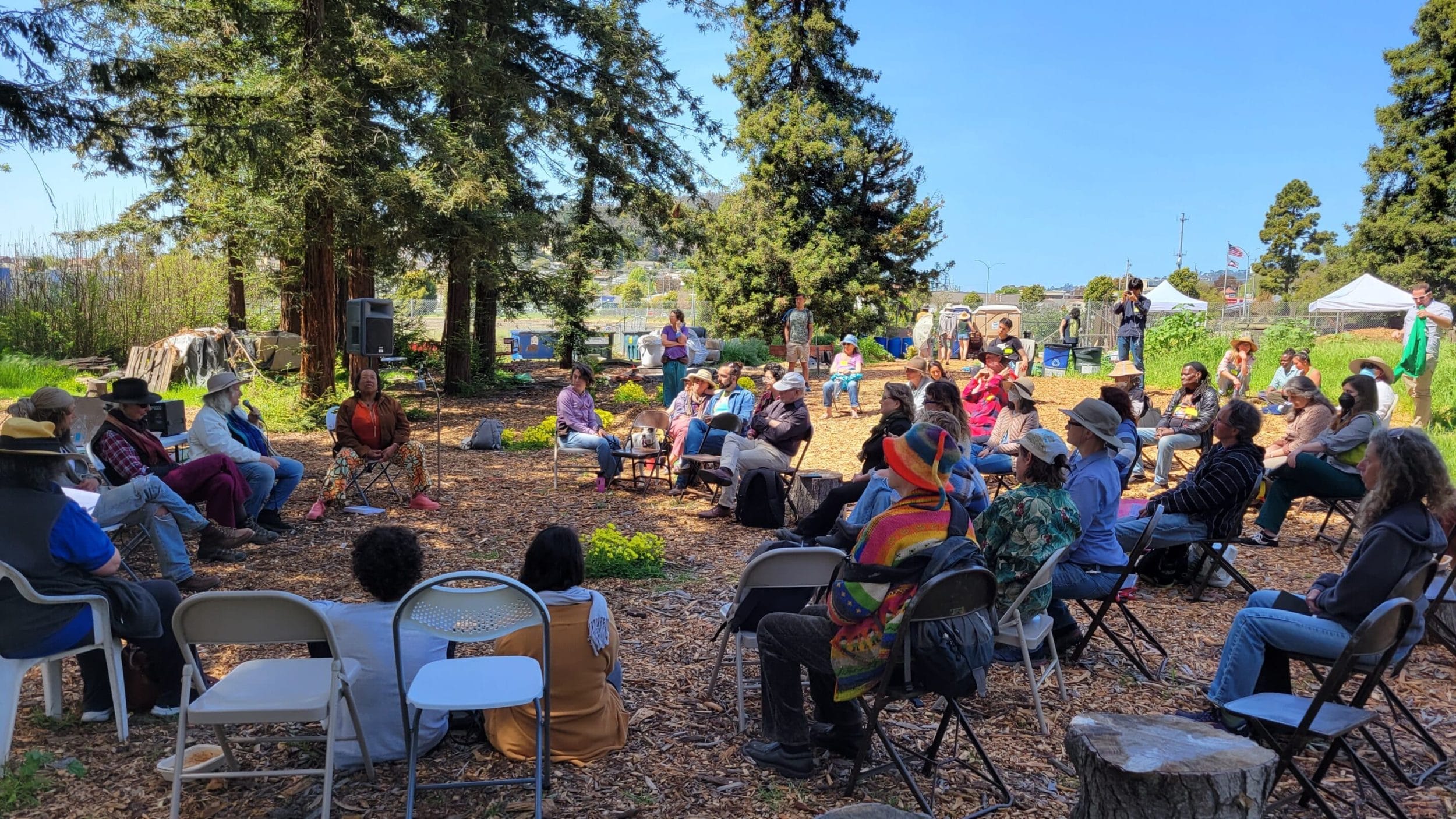 Image of author Tomi Hazel Vaarde together with other panelists for Earth Day panel at Gill Tract Farm. People sitting outside listening to a talk.